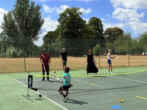 Family playing tennis together at a local community court